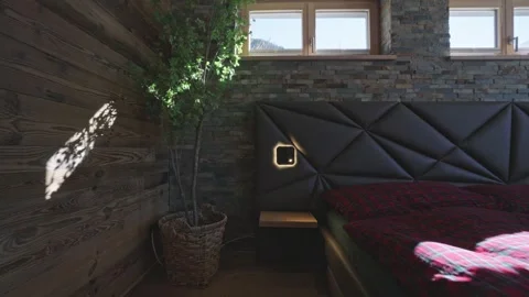 Sunlight casting moving shadows in a cozy bedroom with wood and stone walls in a Stock Footage 335198737