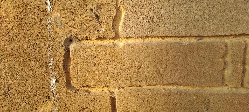 Sunlight casting shadows on weathered brick wall Stock Photos