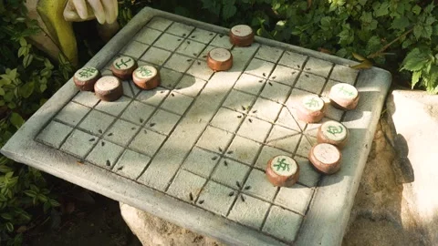 Sunlight casting warm glow on partially played xiangqi board, stone surface Video stock 315701651