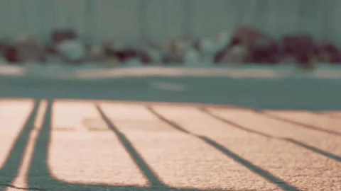 Sunlight casts long shadows on pavement during late afternoon Stock Footage 343931943