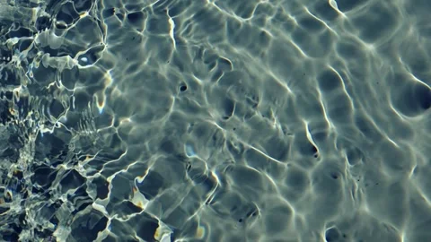 Sunlight caustics and ripples on clear water surface closeup Stock Footage 338343982