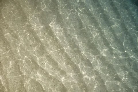 Sunlight Caustics on Sandy Seabed in Shallow Water Stock Photos