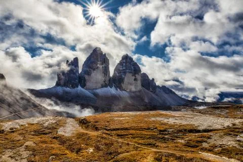 Sunlight on a cloudy day in Dolomites with a view of famous Tre Cime di Lavar Stock Photos
