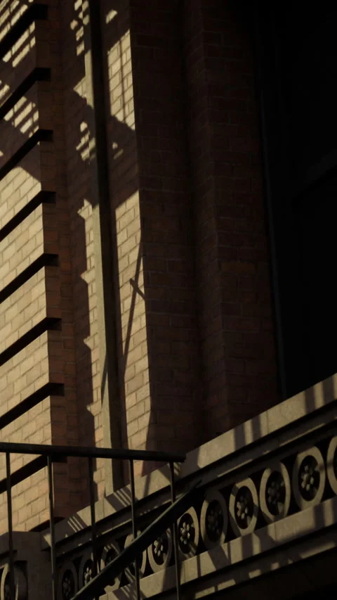 Sunlight creates shadow patterns on building wall during late afternoon Stock Footage 334888673