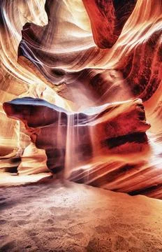 Sunlight creating dramatic patterns on sand and rock formations inside Ante.. Stock Photos
