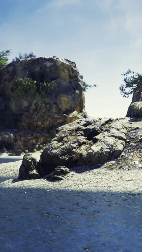 Sunlight dances on calm waters near rocky shores under a bright sky Video stock 334256364