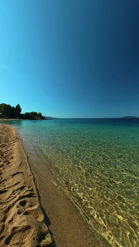 Sunlight dances through gentle waves. Lagomandra, Greece. Vertical Stock Footage 339625622
