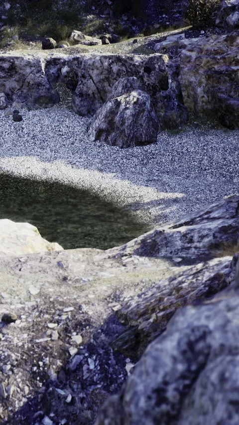 Sunlight dances on tranquil waters at a hidden rocky pool in nature Stock Footage 332204547