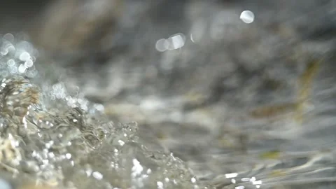 Sunlight effects of clear water flowing over mountain river rocks (slow motion) Stock Footage 212737115