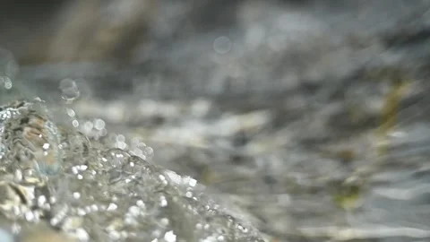 Sunlight effects of clear water flowing over mountain river rocks (slow motion) Stock Footage 212737747