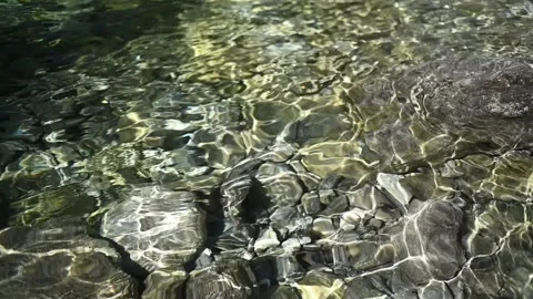 Sunlight effects on stones in the pond of a waterfall (slow motion) 스톡 동영상 260837526