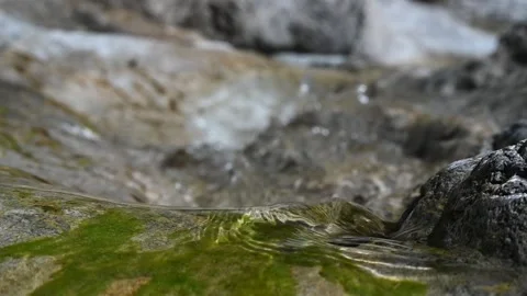 Sunlight effects from water flowing over mossy rocks and bokeh (slow motion) Stock Footage 212731850