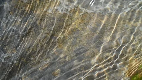 Sunlight effects on water that flows over a rock (slow motion) Stock-Footage 212735804