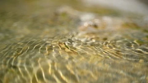 Sunlight effects in water of a rocky mountain river (slow motion, bokeh) Video stock 212730846