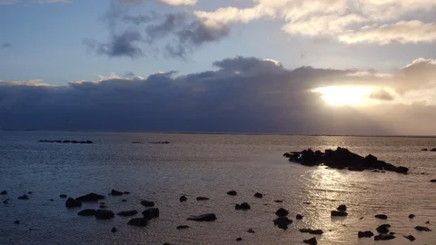 Sunlight falling through clouds on a sea during sunset Stock Footage 105418259