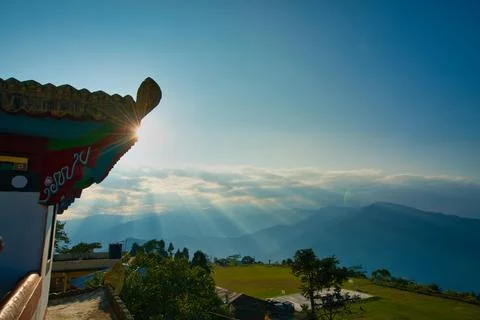 Sunlight falls on the mountain through the clouds. Corner of the temple roof. Stock Photos