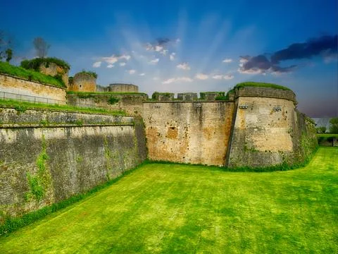 Sunlight filtering through clouds, highlighting medieval fortress walls of .. Stock Photos