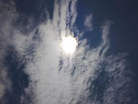Sunlight filtering through a dramatic sky with billowing white clouds Stock Photos