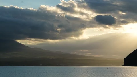 Sunlight filtering through dramatic sunset clouds, lake Yamanaka, Yamanashi Stock Footage 249639616