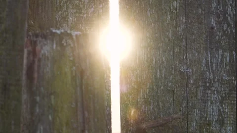 Sunlight filtering through a gap in old rustic wooden fence Stock Footage 288198895