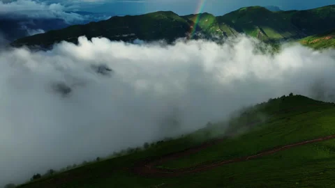 Sunlight filtering through the mist over green mountains. Sunlight Breaking Video stock 265038889