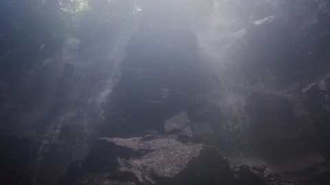 Sunlight filtering through mist at a tropical waterfall 動画素材 340845697