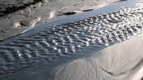 Sunlight filtering through shallow water, streaming over sandy landscape Stock-Footage 301918120