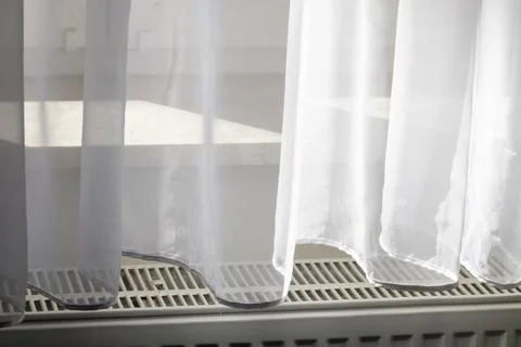 Sunlight filtering through sheer white curtains, creating a soft and airy Foto stock