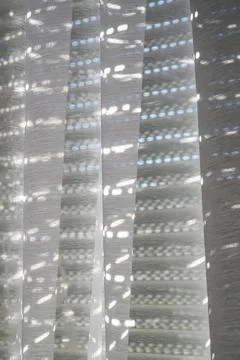 Sunlight filtering through sheer white curtains creating a pattern of light.. 写真素材