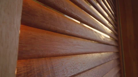 Sunlight filtering through the slats of louvered wooden door Stock Footage 260524966
