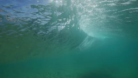 Sunlight Filters Through Breaking Wave in Clear Turquoise Water Video stock 344386391