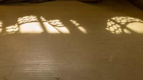 Sunlight filters through curtains onto a dusty wooden table, time flies fast Stock Footage 334160318