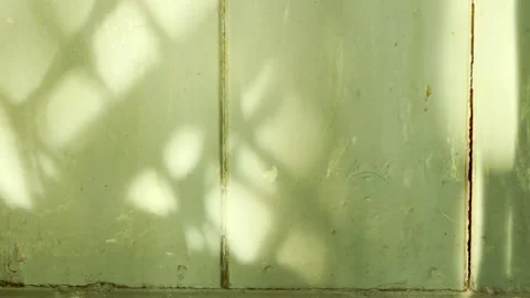 Sunlight Filters Through Macrame Netting Onto A Distressed Green Wooden Wall Stockbeeldmateriaal 334121135