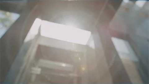 Sunlight flaring through building architecture camera pan Stock Footage 102597847