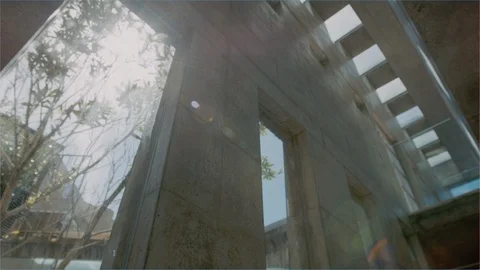 Sunlight flaring through building architecture low angle pan Stock Footage 102628846