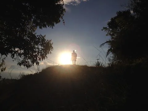 Sunlight getting through the clouds and mountains at sunset Stock Photos