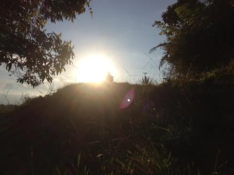Sunlight getting through the clouds and mountains at sunset Stock Photos