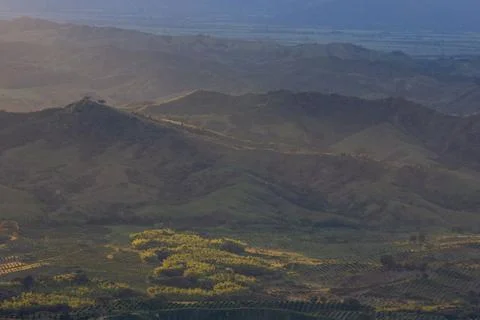 Sunlight getting through the clouds and mountains at sunset Stock Photos