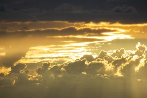 Sunlight getting through the clouds and mountains at sunset Stockfoto's