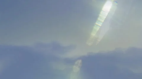 Sunlight glare piercing through soft blue clouds during bright afternoon sky 스톡 동영상 343843018