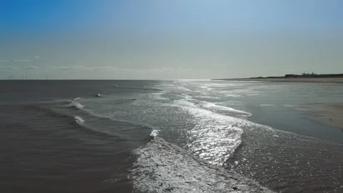 Sunlight glints off gentle waves rolling toward shore Stock Footage 346259748