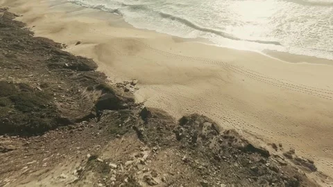 Sunlight glints off ocean waves crashing on soft sand Stock Footage 341826268
