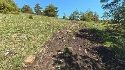 Sunlight glints off rocky trail winding uphill. Balkan, Eastern Europe, POV Video stock 333440694