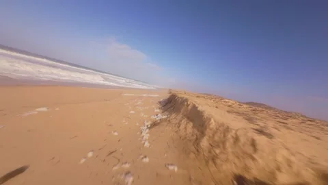 Sunlight glints off water as waves wash over warm, sunlit sand Video stock 345058399