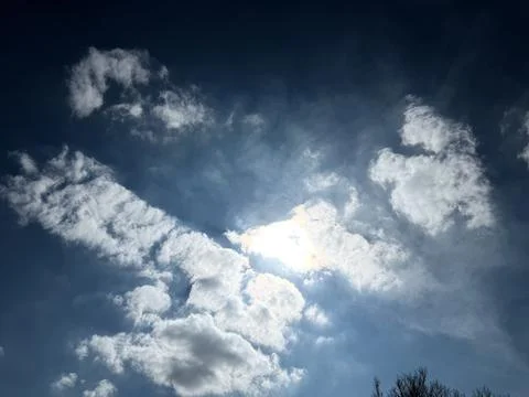 Sunlight Glowing Behind Thick White Clouds Stock-Fotos