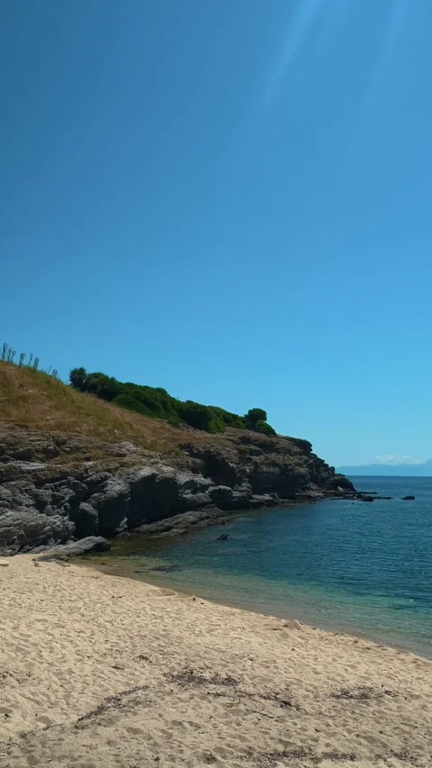 Sunlight glows bright against deep blue sky. Trani Ammouda, Greece. Vertical Stock Footage 339629551