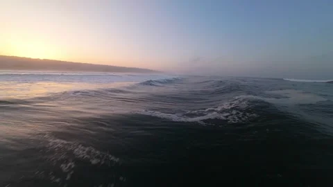 Sunlight glows over ocean surface, mist drifts with gentle waves 库存影片 346168253