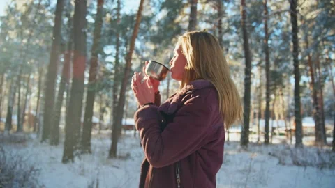 Sunlight glows softly behind woman in winter forest Video stock 342782899