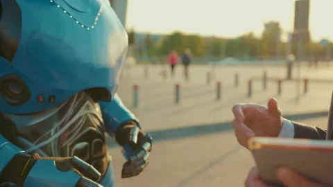 At sunlight hand of a man shaking hands with a robot human interaction with Stock Footage 133299893