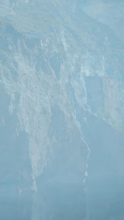 Sunlight hits rocky cliffs near blue water on a clear day in nature Stock Footage 341270450